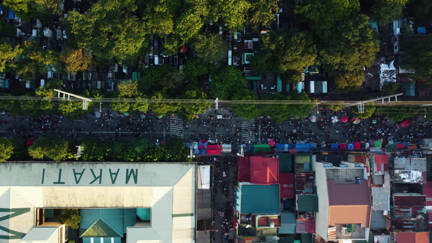 Overhead drone shot of crowded streets of Makati, sunny evening in Philippines
