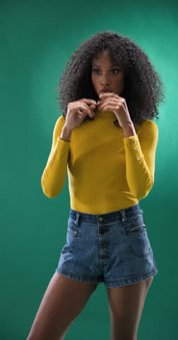Vertical video: Joyful woman in yellow top and denim shorts clapping hands, feeling excited. Cheerful, happiness, applause, celebration, casual, summer