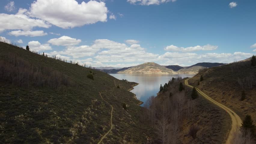 Scenic drone flyovers of Strawberry Reservoir in Utah, featuring alpine forests, rivers, rocky terrain, and vibrant spring colors in cinematic aerial views.
