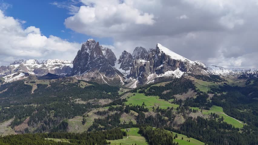 Alpe di Siusi landscape with Sassolungo Group, featuring a drone’s slow circular view of meadows and rugged mountains in the Dolomites