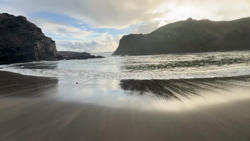 Beautiful lagoon and ocean beach in Piha, Auckland, New Zealand, before sunset.