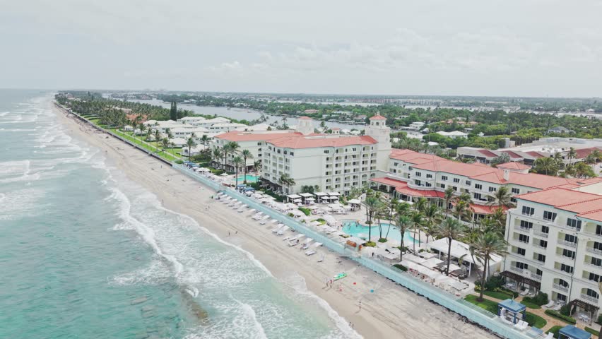 Jib up drone shot of beach and hotels next to Atlantic Ocean with cloudy weather during the day in West Palm Beach, Florida, USA