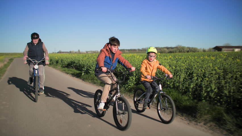 Two young boys on bicycles accompany their grandparents on a bike ride