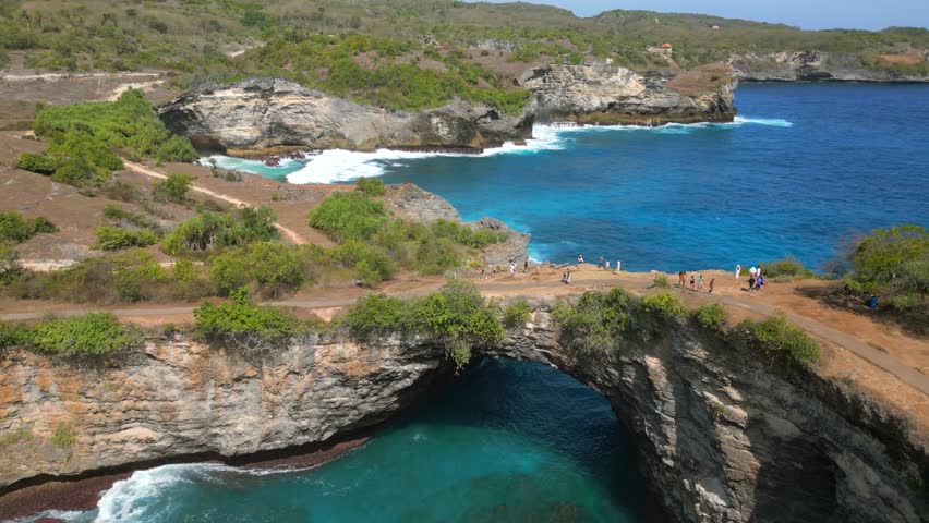 Aerial view of Broken Beach and Angel's Billabong on Nusa Penida, Bali. Famous coastal rock formation with natural arch and turquoise waters. Ideal for travel and nature themes.