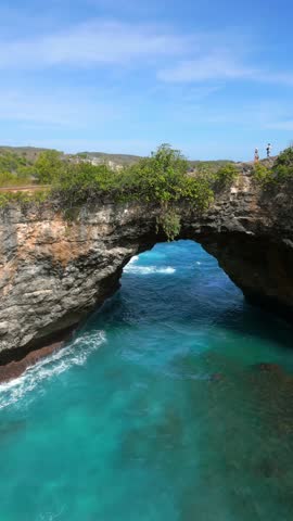Aerial view of Broken Beach and Angel's Billabong on Nusa Penida, Bali. Famous coastal rock formation with natural arch and turquoise waters. Ideal for travel and nature themes.