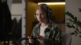 Frowned focused unhappy Caucasian little girl teen child kid influencer blogger schoolgirl gamer player streaming playing video game at home use controller wireless headphones tournament competition - Powered by Shutterstock - Get 15% off with code: PIKWIZARD15