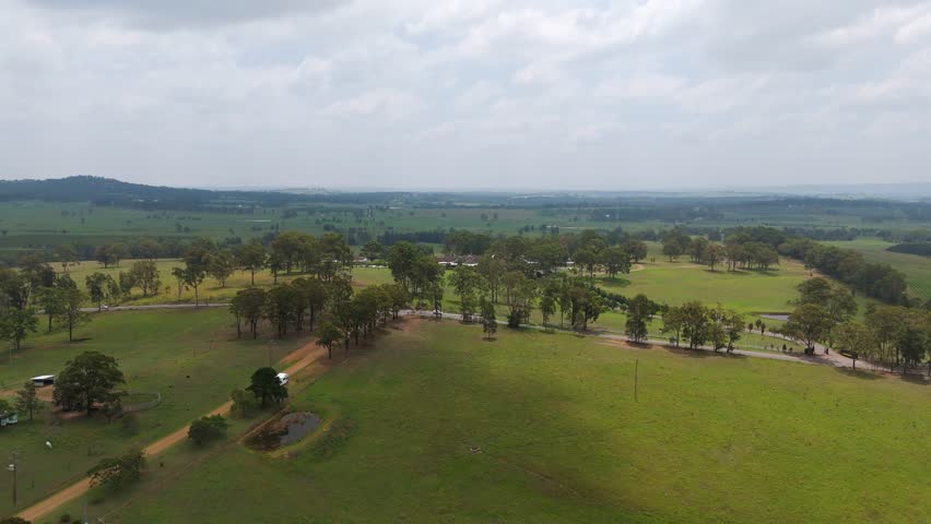 Aerial establishing drone fly green fields, roads and vehicles at The Hunter Valley NSW Wine Region of Australia