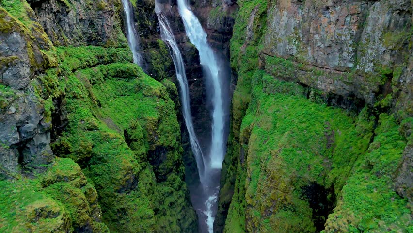 Explore the breathtaking beauty of Iceland as powerful waterfalls flow gracefully down verdant cliffs. Glymur waterfall canyon in Iceland