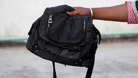Female hand holding old, torn black fabric handbag. Discolored, well-used purse showing wear and tear. Vintage fashion accessory. - Powered by Shutterstock - Get 15% off with code: PIKWIZARD15