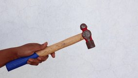 Woman's hand holding an iron hammer with a wooden handle. Essential hand tool for construction, repair, and shaping materials. - Powered by Shutterstock - Get 15% off with code: PIKWIZARD15