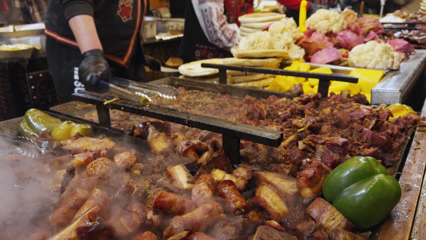 Christmas market Bucharest Romania featuring grilled national meat and vegetable dishes near Parliament, festive food court attracting visitors with traditional Romanian holiday cuisine