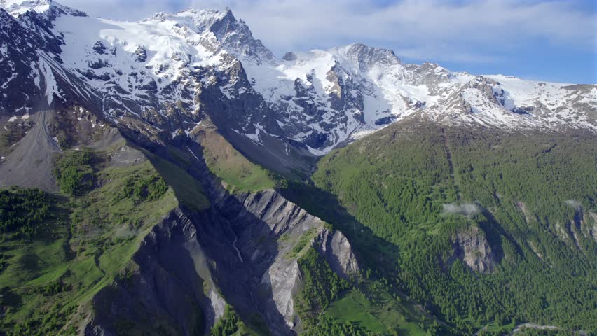 White capped Glacier of Meije in the Parc national des Écrins over looks the village of La Grave during springtime in the French Alps
