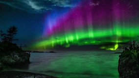 A stunning night sky with vibrant purple and green aurora, framing the lone silhouette of a tree and a small building. - Powered by Shutterstock - Get 15% off with code: PIKWIZARD15