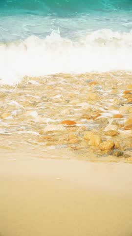 Transparent waves slowly roll onto the beach. Close-up of clean sand with sea water. Background with empty space on the theme of summer holidays and travel.