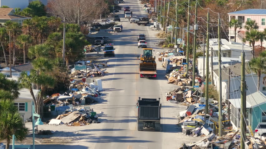 Consequences of natural disaster. Trash from severely damaged houses after hurricane Milton storm surge. Piles of debris on street side on Manasota key street in Florida.