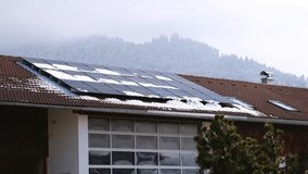 Close-up of snow melting on modern solar panels. Snow covered roof on foggy winter day in the Bavarian Alp region. Concept of low effectivity of producing renewable electricity or clean energy. - Powered by Shutterstock - Get 15% off with code: PIKWIZARD15
