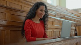 Smiling happy positive Latina woman student girl female typing laptop online chatting using net internet class lesson preparing to exam in university college academy auditorium studying with computer - Powered by Shutterstock - Get 15% off with code: PIKWIZARD15