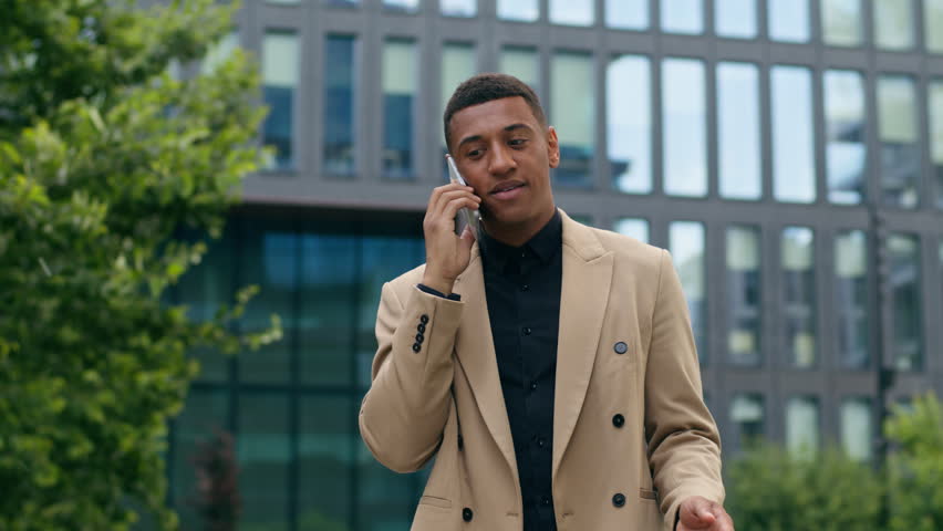 African American man guy male consulting client by call businessman business salesman entrepreneur employer talking mobile phone stand in city negotiation smartphone communicate conversation working - Powered by Shutterstock - Get 15% off with code: PIKWIZARD15