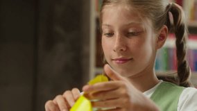 Smiling cute kid Caucasian child lovely little girl pupil daughter schoolgirl student education school learn study lesson art class origami showing paper frame yellow color love symbol affection sign - Powered by Shutterstock - Get 15% off with code: PIKWIZARD15