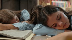 Four pupils exhausted tired sleeping napping in library school table sleep on books textbooks Caucasian friends teenagers one boy guy three girls teens studying boring fall asleep education together - Powered by Shutterstock - Get 15% off with code: PIKWIZARD15