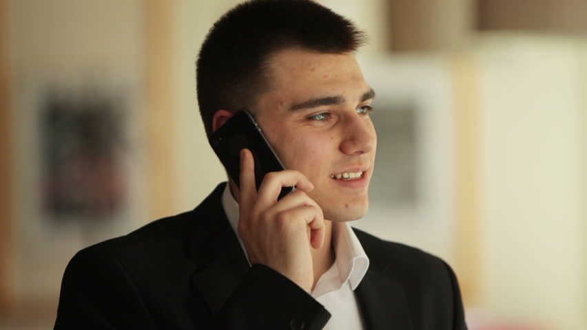 Young man speaking by phone and laughing

