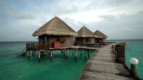 Overwater Bungalows Connected by Wooden Pier in Tropical Lagoon - Powered by Shutterstock - Get 15% off with code: PIKWIZARD15