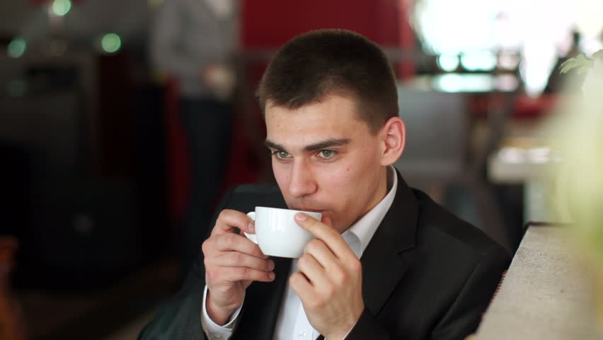 Young man drinking coffee and laughing
