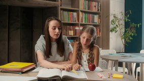 Caucasian woman teacher little girl child pupil schoolgirl studying reading book school college looking at camera smiling portrait learning lesson classroom kid prepare exam textbook education student - Powered by Shutterstock - Get 15% off with code: PIKWIZARD15