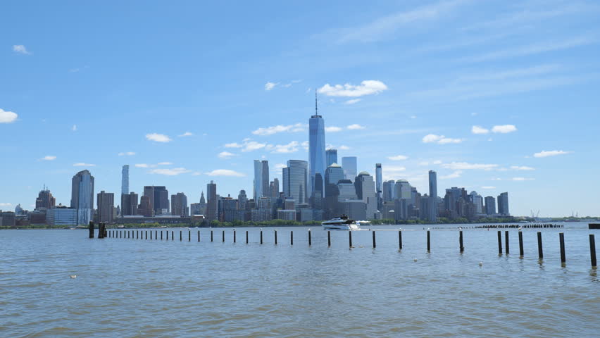 New York City, USA - May 21, 2025: Iconic Manhattan’s view across the Hudson River under blue skies.