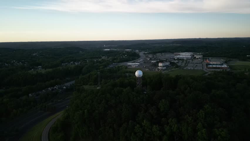 High aerial above weather radar tower in Charleston West Virginia state forest at dusk