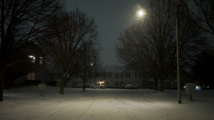 Stabile shot of the residential street covered with the snow at winter snow storm night time
