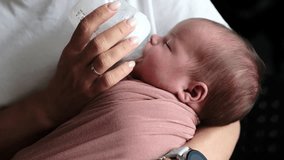 Mother Feeds Newborn Baby Formula From A Bottle As The Infant Consumes Milk Formula - Powered by Shutterstock - Get 15% off with code: PIKWIZARD15