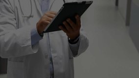 Male physician tapping tablet launching network view for health data study across hospital corridor. Medical, technology, digital, healthcare, futuristic, analytics, connectivity - Powered by Shutterstock - Get 15% off with code: PIKWIZARD15