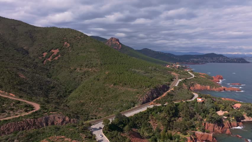 Aerial view of mountain road beside turquoise sea, Esterel coast, France