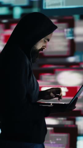 Vertical Video Conceptual representation of cyber crime with male hacker exploiting system vulnerability, using programming technique and surveillance to override digital defenses and leak information
