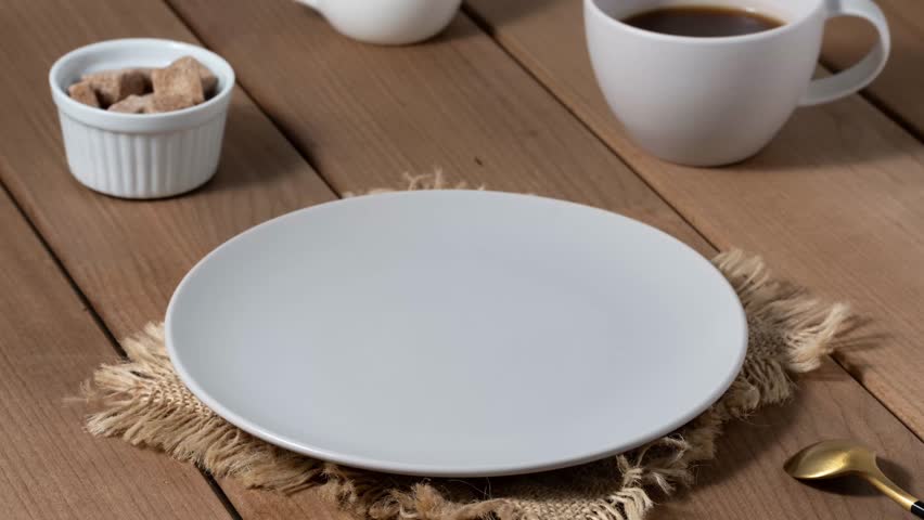 Delicious heart-shaped waffles served with coffee and sugar cubes on a rustic wooden table. Stop motion animation.