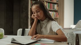 Bored schoolgirl Caucasian girl kid child pupil read book in school library sad tired learner student teenager upset frustrated boring lesson exhausted sleepy reading studying in classroom education - Powered by Shutterstock - Get 15% off with code: PIKWIZARD15
