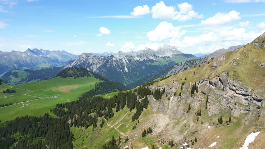 Aerial: valley below Lake Lioson during the day in Ormont-Dessous, near Les Mosses, in the canton of Vaud, Switzerland, jib up drone shot
