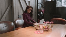 Focused mid age businesswoman in a business outfit utilizes her laptop while seated in a modern setting, surrounded by natural decor - Powered by Shutterstock - Get 15% off with code: PIKWIZARD15