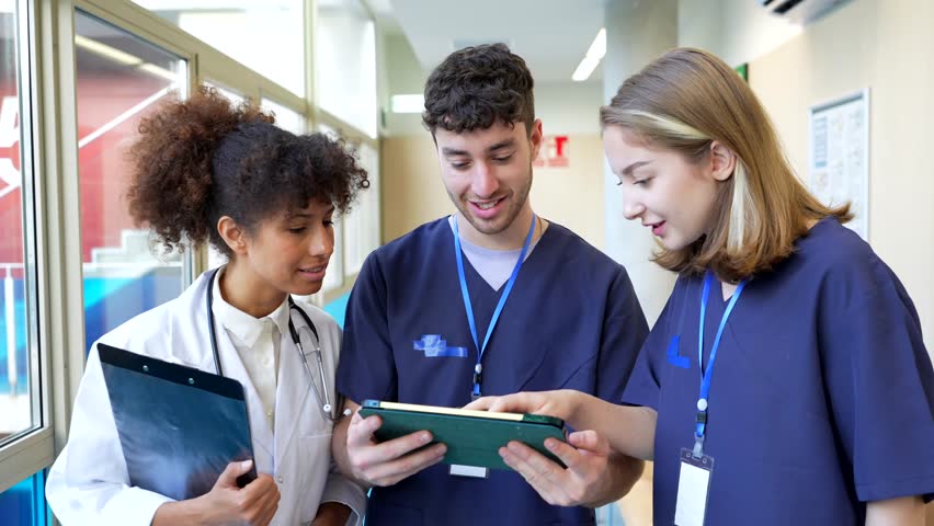Doctors and nurses review patient information on a tablet, fostering teamwork and informed decision making in healthcare