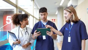 Medical professionals collaborating while walking hospital corridor, reviewing digital health records on tablet, discussing patient information with focused expertise - Powered by Shutterstock - Get 15% off with code: PIKWIZARD15