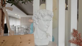 White plaster bust sculpture placed near modern white vertical slats in a bright interior space - Powered by Shutterstock - Get 15% off with code: PIKWIZARD15