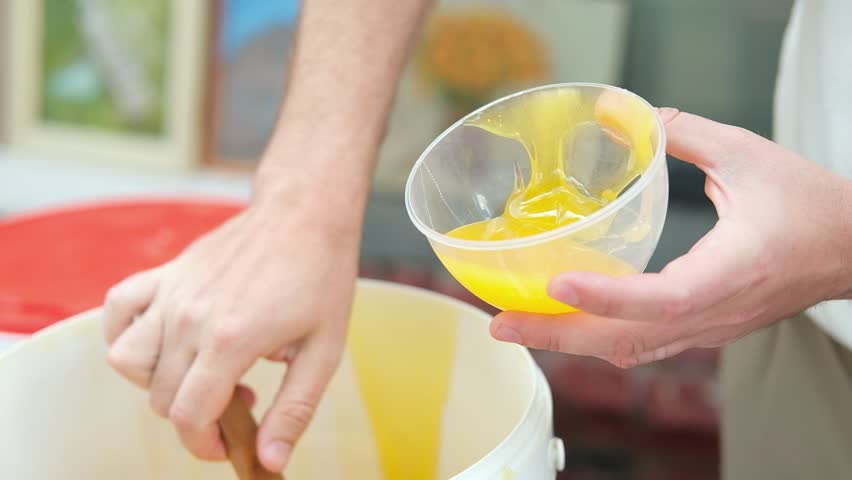Honey dripping. Dipping honey with honey wooden spoon in plastic jar. Healthy organic food