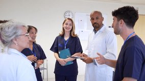 Medical team warmly welcoming new intern, celebrating professional milestone with handshakes, smiles, and supportive gestures inside bright hospital setting - Powered by Shutterstock - Get 15% off with code: PIKWIZARD15