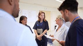 Doctors and nurses review medical charts during a briefing in a hospital hallway, fostering collaboration and informed decision making - Powered by Shutterstock - Get 15% off with code: PIKWIZARD15