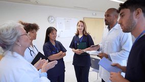 Healthcare professionals discussing patient information while standing in hospital corridor, collaborating and sharing medical insights during team consultation - Powered by Shutterstock - Get 15% off with code: PIKWIZARD15
