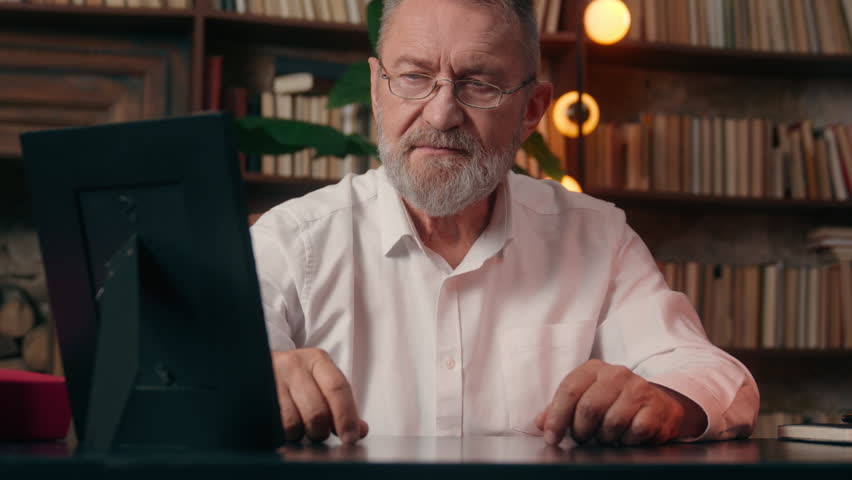 Old Caucasian man holding photo frame photograph looking memory remember male businessman business nostalgia indoor office mature senior grandfather takes off glasses vision medicine health eyesight