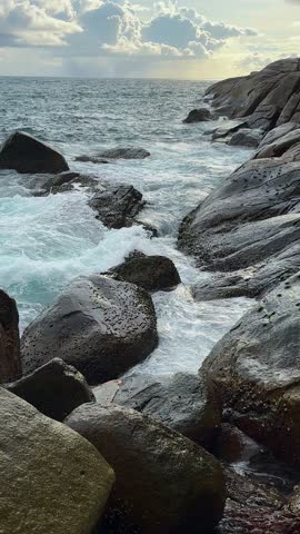 Powerful waves crashing against stones shaping shoreline rocks under open sky. Coastal erosion, dynamic sea tide, natural rock formation, ocean force, wild beach, water impact, power in nature