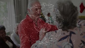 Senior man offering hand to senior woman and starting spin in living room for Christmas gathering. Festivity, celebration, companionship, elegance, joy, tradition, warmth - Powered by Shutterstock - Get 15% off with code: PIKWIZARD15