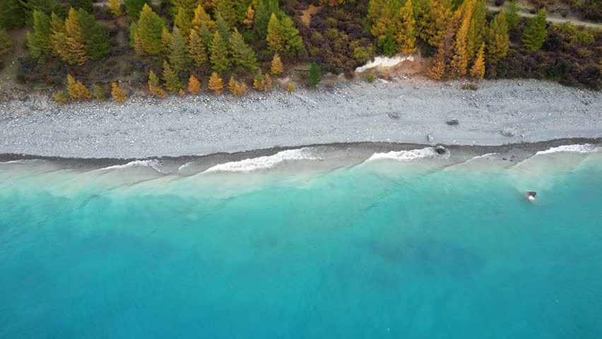 Waves In The Shore Of Lake Tekapo With Turquoise Blue Water In South Island, New Zealand. - aerial shot
